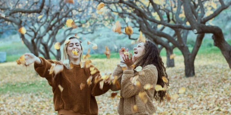 Friends laughing with fall leaves