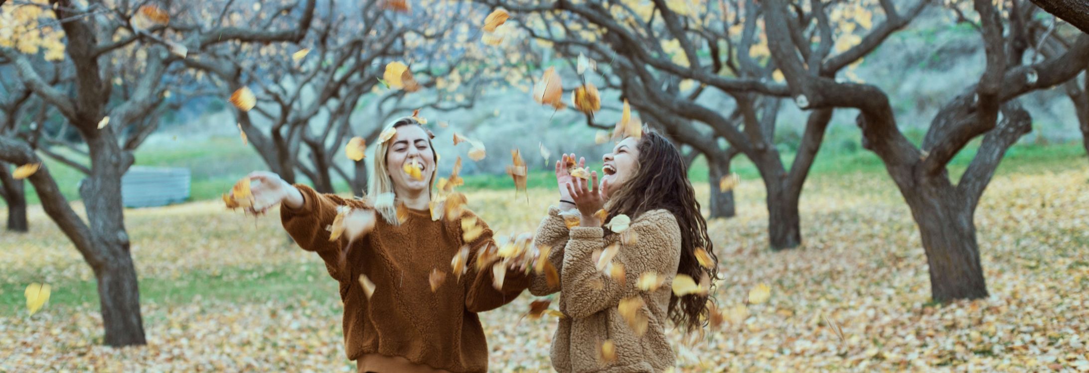 Friends laughing with fall leaves
