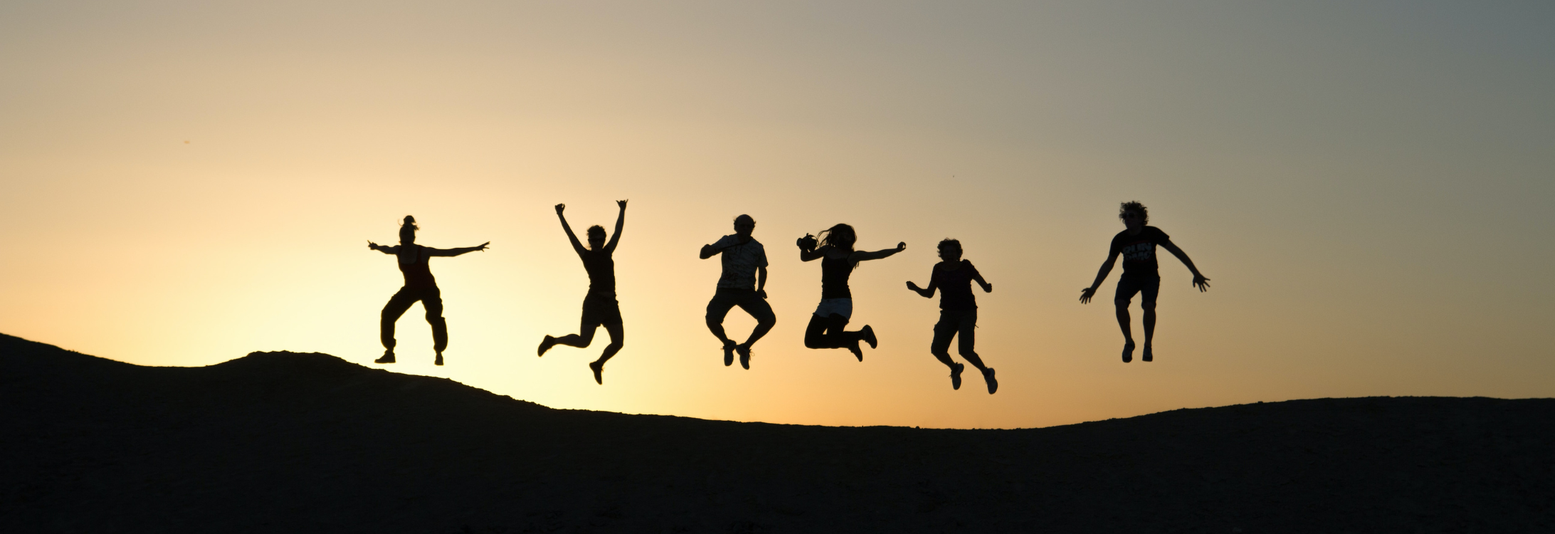 people jumping in a sunset
